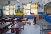 Nhân viên dọn dẹp phòng học để đón học sinh trở lại lớp