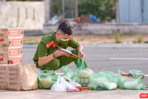 Chiến sĩ trẻ soát lại đơn hàng nhu yếu phẩm của người dân trước khi giao (Ảnh: Nghĩa Hiếu)