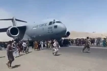 Cảnh người dân bám và chạy theo khi chiếc C-17 cất cánh (Ảnh: Đông Phương).