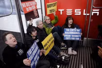 Người biểu tình chống Elon Musk vào ngồi lỳ trong cửa hàng Tesla cản trở hoạt động kinh doanh. Ảnh: QQnews.