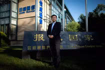 Vương Tịnh đứng trước trụ sở Tập đoàn Xinwei với Slogan "Báo hiếu quốc gia" (Ảnh: Sina)