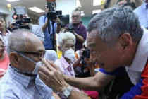 Do dịch bệnh bùng phát trở lại, Singapore ban hành lệnh bắt buộc người ra đường phải đeo khẩu trang. Trong ảnh: Thủ tướng Lý Hiển Long đeo khẩu trang cho người dân (Ảnh: Guancha).