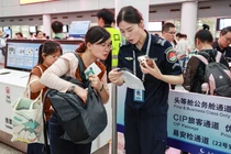 Nhân viên an ninh sân bay kiểm tra cục sạc dự phòng của hành khách. Ảnh: Sohu.