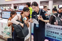 Nhân viên an ninh sân bay kiểm tra cục sạc dự phòng của hành khách. Ảnh: Sohu.