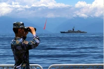 Ảnh do Tân Hoa xã công bố cho thấy lính Trung Quốc đang quan sát tàu Đài Loan, phía xa là kiến trúc được cho là ống khói Nhà máy điện Hòa Bình, Hoa Liên (Ảnh: Xinhua).