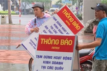 Nhân viên Ban quản lý bán đảo Sơn Trà và các bãi biển du lịch Đà Nẵng dựng bảng thông báo tạm dừng hoạt động kinh doanh tại các kiot ven biển để tiến hành đấu giá theo quy định