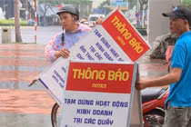 Nhân viên Ban quản lý bán đảo Sơn Trà và các bãi biển du lịch Đà Nẵng dựng bảng thông báo tạm dừng hoạt động kinh doanh tại các kiot ven biển để tiến hành đấu giá theo quy định