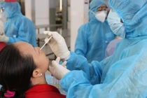 Lấy mẫu xét nghiệm COVID-19. Ảnh: HCDC