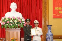 Bộ trưởng Tô Lâm trao quyết định thăng cấp bậc hàm Trung tướng của Chủ tịch nước và tặng hoa chúc mừng đồng chí Nguyễn Văn Sơn.