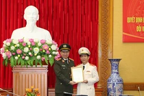 Bộ trưởng Tô Lâm trao quyết định thăng cấp bậc hàm Trung tướng của Chủ tịch nước và tặng hoa chúc mừng đồng chí Nguyễn Văn Sơn.