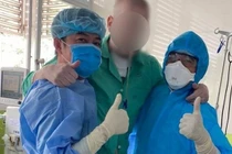 Bệnh nhân 91 đứng dậy tập đi với sự hỗ trợ các bác sĩ BV Chợ Rẫy (Ảnh: N.L.)