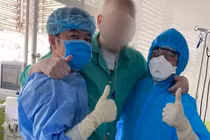 Bệnh nhân 91 đứng dậy tập đi với sự hỗ trợ các bác sĩ BV Chợ Rẫy (Ảnh: N.L.)