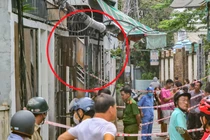 Lực lượng Công an đang phong toả hiện trường căn nhà (khoanh đỏ) bị cháy để điều tra