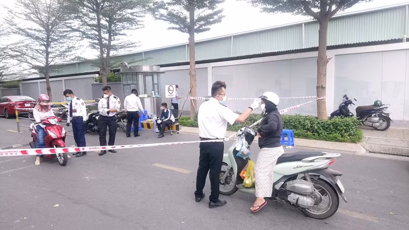 Kiểm tra thân nhiệt người ra vào tại một chung cư trên địa bàn TP.HCM. Ảnh: A.L