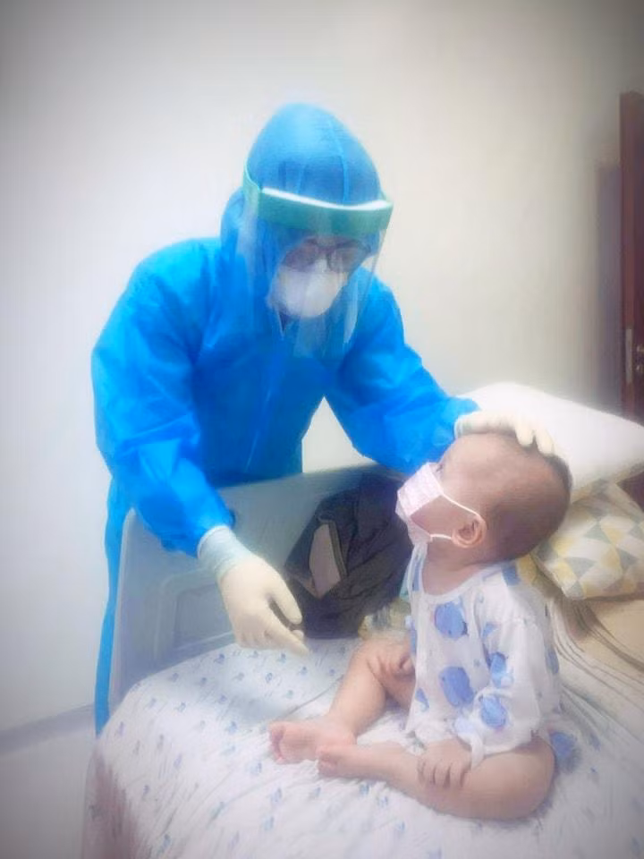 Bác sĩ dỗ dành em bé mắc COVID-19 đang điều trị tại BV Nhi đồng Thành phố. Ảnh: BNNĐTP cung cấp