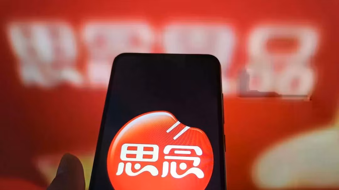Một người dùng Internet đang xem trang web của Synear Food trên máy tính của mình, trong khi logo của công ty hiển thị trên điện thoại. Công ty này đã bị Washington đưa vào danh sách đen vì bị cáo buộc sử dụng lao động cưỡng bức. Ảnh: Getty.