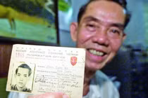 Ông Phạm Xuân Ẩn và tấm thẻ nhà báo năm 1965 tại nhà riêng ở thành phố Hồ Chí Minh, Việt Nam, ngày 26/4/2000. Ảnh tư liệu