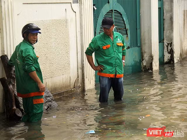 Màu áo xanh quen thuộc của các công nhân thoát nước trên đường phố Sài Gòn sau mỗi trận mưa to.