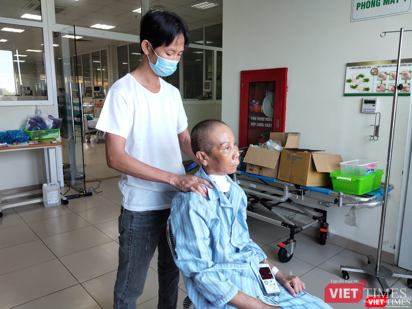 Con trai bệnh nhân 20 chăm sóc cho mẹ. Ảnh: Minh Thúy