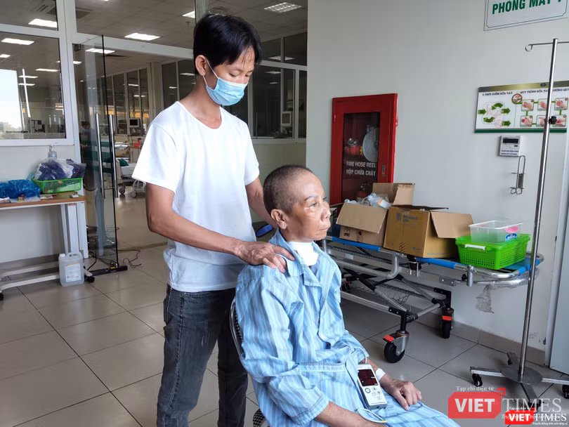 Con trai bệnh nhân 20 chăm sóc cho mẹ. Ảnh: Minh Thúy