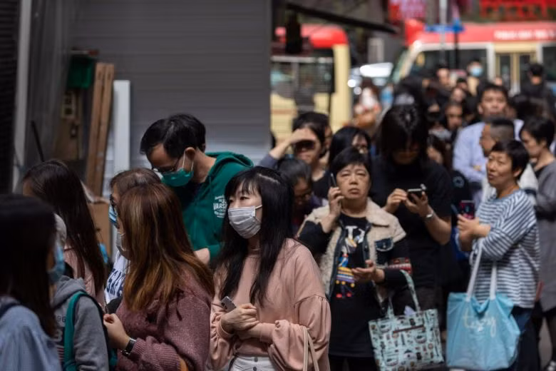 Người dân xếp hàng để nhận viên vitamin C miễn phí và thuốc khử trùng tay ở Hồng Kông. Ảnh: EPA-EFE