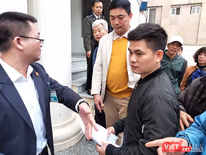 Nhân viên bảo vệ ký túc xá Học viện báo chí và Tuyên truyền làm thủ tục tham dự phiên tòa. Ảnh: Minh Thúy