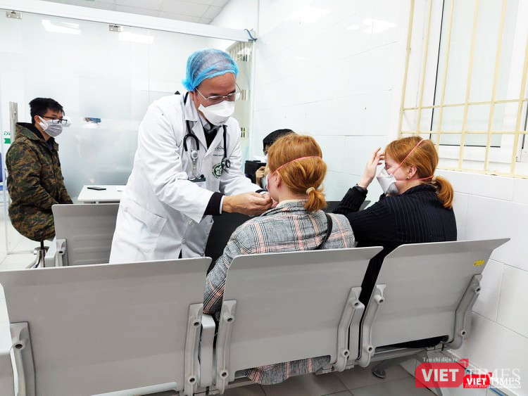 Bác sĩ hướng dẫn người đến khám đeo khẩu trang. Ảnh: Minh Thúy Bác sĩ hướng dẫn người đến khám đeo khẩu trang. Ảnh: Minh Thúy
