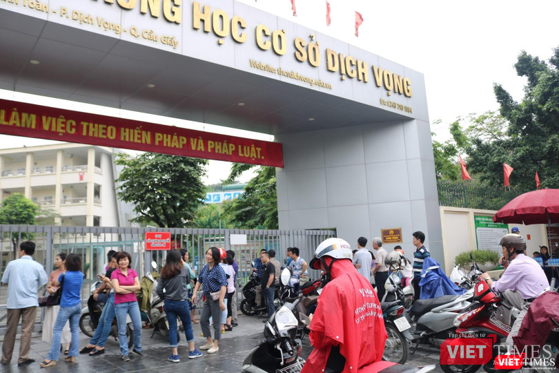 Nhiều phụ huynh đội mưa đưa con đi thi . Ảnh: Minh Thúy