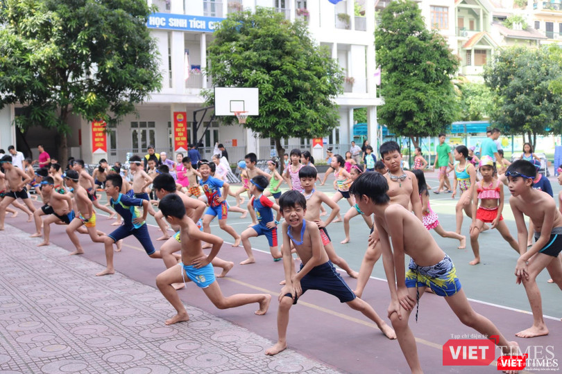 Học sinh khởi động theo hướng dẫn của thầy cô trước khi thực hành môn bơi. Ảnh: Minh Thúy.