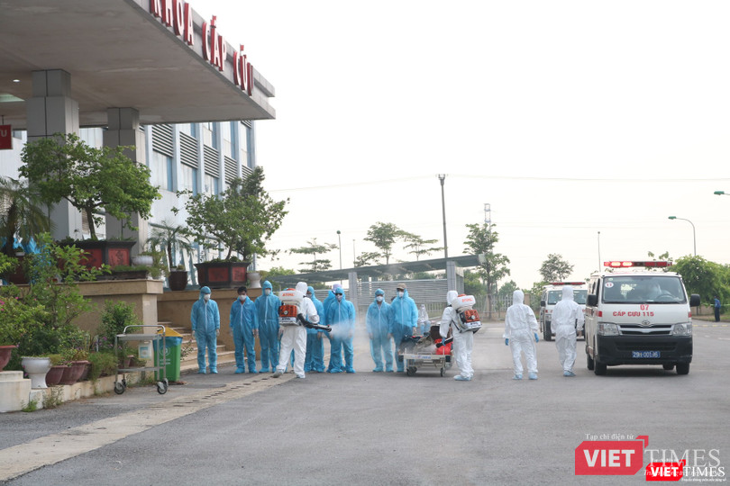 Các công dân Việt Nam về từ Guinea Xích đạo được phun khử khuẩn trước khi vào Bệnh viện (Ảnh: Minh Thúy)