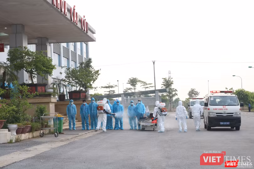 Các công dân Việt Nam về từ Guinea Xích đạo được phun khử khuẩn trước khi vào Bệnh viện (Ảnh: Minh Thúy)