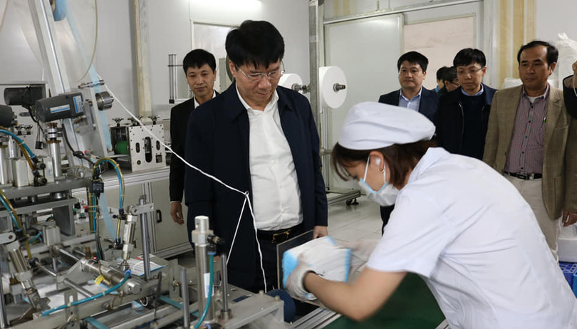 Thứ trưởng Bộ Y tế Trương Quốc Cường quan sát hoạt động sản xuất khẩu trang. Ảnh: Khánh Phương