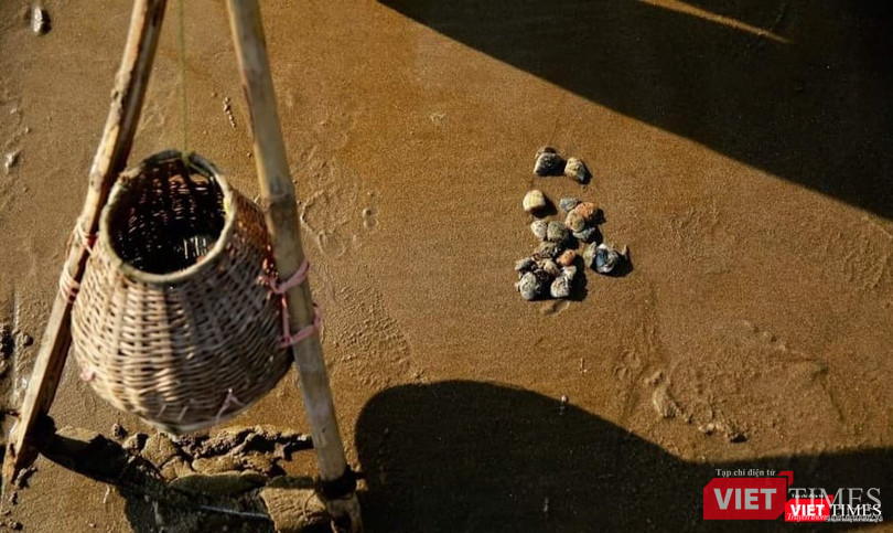 Dụng cụ cào ngao được làm bằng thanh tre, một giỏ tre treo lủng lẳng giữa thân