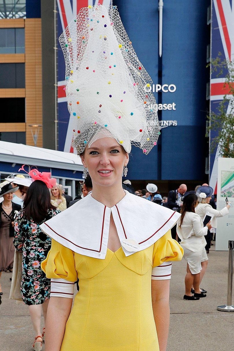 Charlotte Carroll đã đội một chiếc mũ bằng vải tuyn cao chọc trời với các dải trang trí nhiều màu trong suốt.