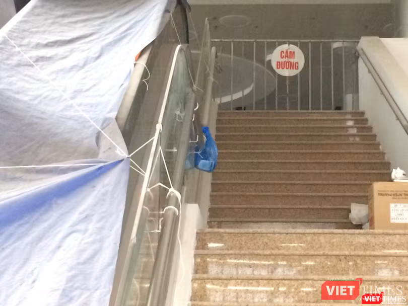 Khu vực cầu thang dẫn lên tầng 2 của BV Bạch Mai cơ sở 2 bị khóa, khu vực cầu thang cuốn đã hoàn thành nhưng bị phủ bạt kín.