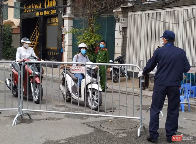 Một vài người được phép ra khỏi khu vực cách ly (tại phố Trúc Bạch - Hà Nội) sau khi hoàn thành nhiệm vụ. Sau đó, barie lại tiếp tục đóng lại. Ảnh: Anh Lê