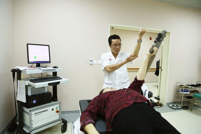 Bác sĩ hướng dẫn bệnh nhân tập phục hồi chức năng với máy. Bác sĩ hướng dẫn bệnh nhân tập phục hồi chức năng với máy.