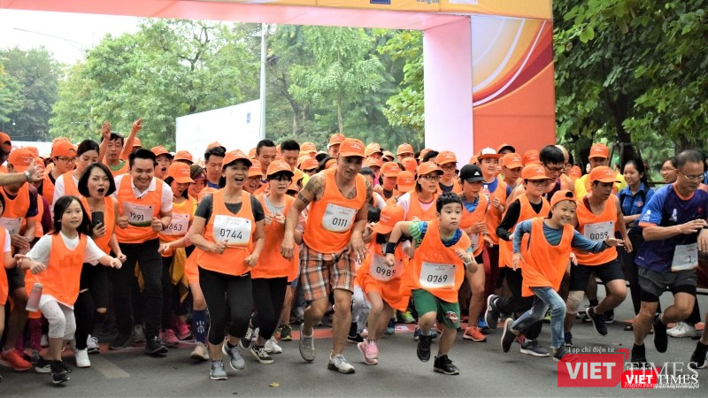 Nhóm mặc áo cam chạy cự ly 5km lao mình ra khỏi vạch xuất phát. Không chỉ người lớn mà nhiều bạn nhỏ cũng hăng hái tham gia thi chạy ở cự ly này.
