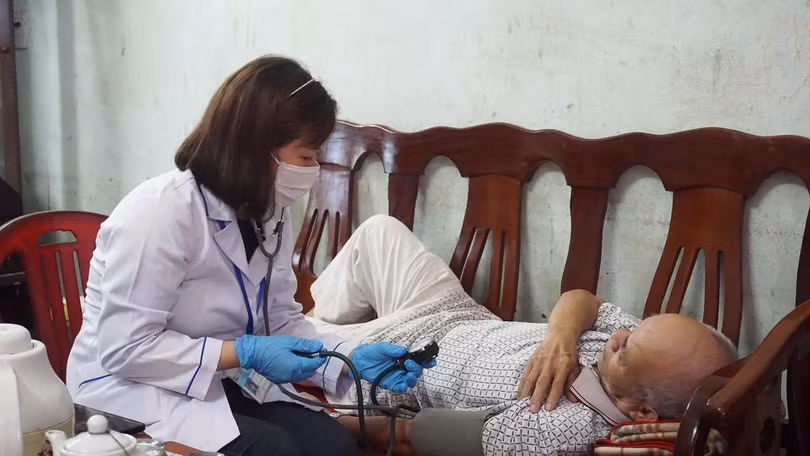 Đối với những bệnh nhân lớn tuổi ngoài việc thực hiện đo thân nhiệt còn được kiểm tra đo huyết áp để theo dõi sức khỏe. Trong ảnh: Cán bộ y tế phường Bạch Đằng (TP Hạ Long) kiểm tra sức khỏe tại nhà cho người dân.