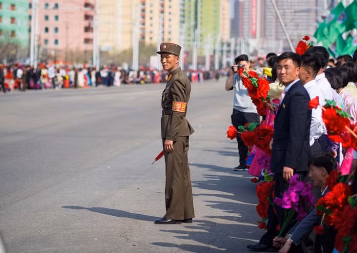 Người lĩnh canh gác khi người dân đang đứng hai bên đường chào đón đoàn diễu hành vào "Ngày Mặt Trời" tổ chức vào ngày 14/4 hàng năm, nhân dịp kỷ niệm ngày sinh của Kim Il-sung Người lĩnh canh gác khi người dân đang đứng hai bên đường chào đón đoàn diễu hành vào "Ngày Mặt Trời" tổ chức vào ngày 14/4 hàng năm, nhân dịp kỷ niệm ngày sinh của Kim Il-sung