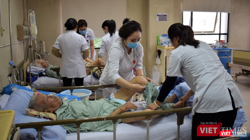 Một bệnh nhân nội trú mắc bệnh nặng được các điều dưỡng vệ sinh thân thể.