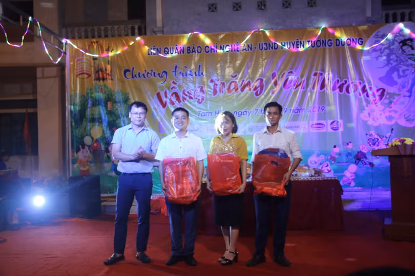 Ông Lê Văn Giáp (bìa trái), chủ tịch CLB Liên quân báo chí Nghệ An trao quà trung thu cho đại diện 3 trường đóng trên địa bà xã tam Hợp.