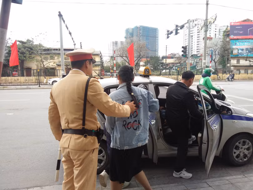 CSGT gọi taxi để bố con anh Hoàng Văn Cường tiếp tục du xuân. Ảnh: Hiệp Bình