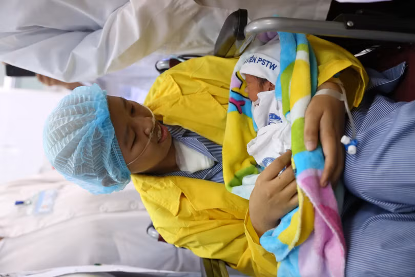 Chị Nguyễn Thị Liên ôm con trai là bé Đỗ Bình An trong lòng