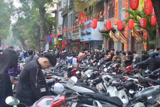 Hàng trăm người xếp hàng dài cả trăm mét kéo dài từ phố Trần Xuân Soạn tới phố Lò Đúc, chờ hàng tiếng đồng hồ để mua được nem về ăn tết.