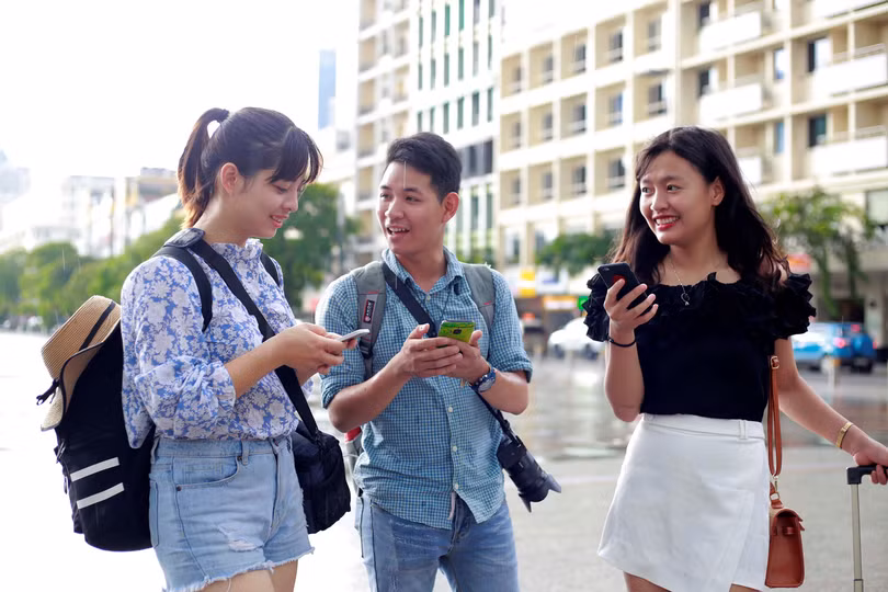Các bạn trẻ sử dụng wifi miễn phí trên phố đi bộ Nguyễn Huệ. Nguồn Thanh Niên 