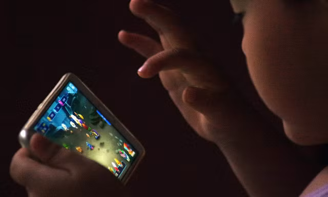 Một em bé đang chơi game online trên thiết bị di động - Ảnh: VCG/VCG 