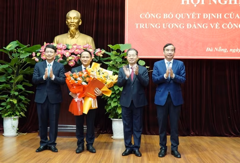 Ông Nguyễn Đình Vĩnh (thứ hai từ trái sang) nhận hoa chúc mừng của lãnh đạo Thành ủy, HĐND, UBND TP Đà Nẵng. 