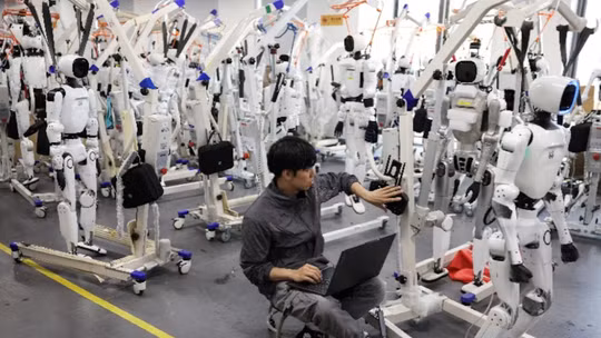 Một kỹ sư đang làm việc giữa các robot hình người Tiangong Omni tại khu vực nghiên cứu và thử nghiệm của Trung tâm Đổi mới Robot Hình người Bắc Kinh, hay còn gọi là X-Humanoid, ở Bắc Kinh, Trung Quốc, ngày 4/9. Ảnh: Reuters.