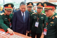 Tổng bí thư Tô Lâm nghe giới thiệu về công nghệ chip bán dẫn tại khu vực triển lãm của Viettel trong lễ khởi công nhà máy chip đầu tiên của Việt Nam.